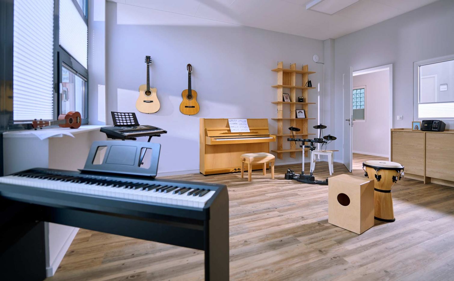 Ein Raum in dem ein Keyboard steht und Gitarren an der Wand hängen